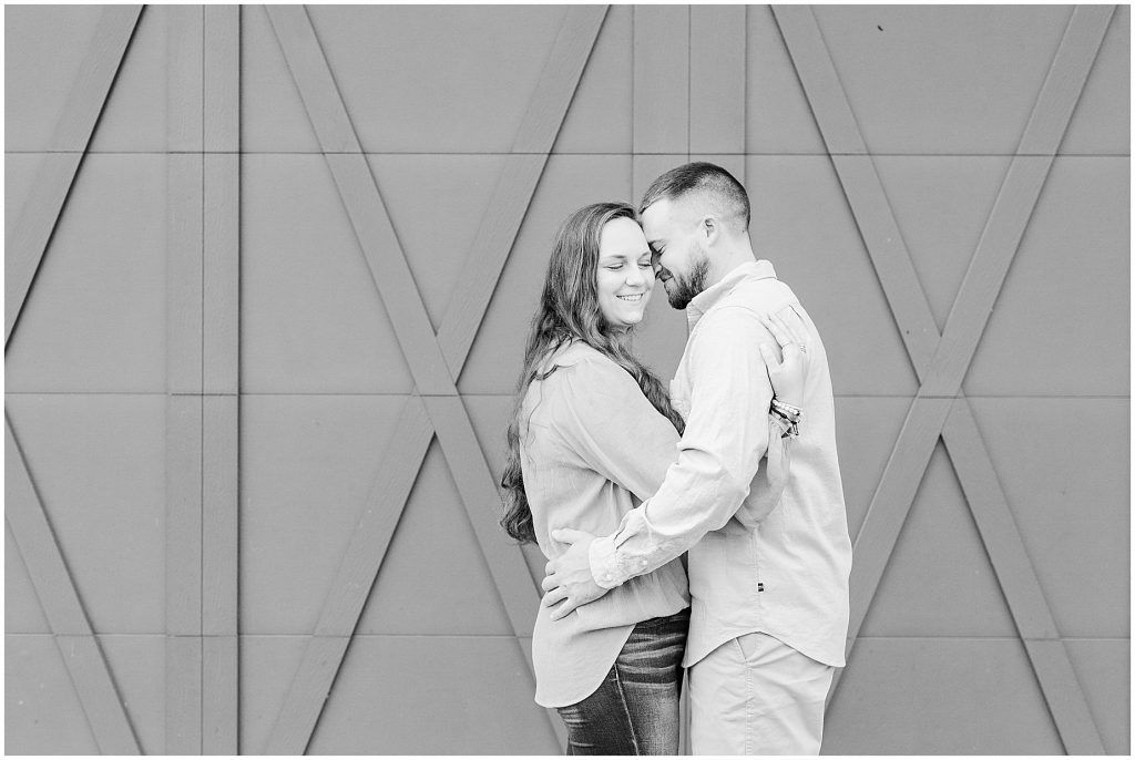 engagement session couple in front of green barn doors at edgewood in black and white