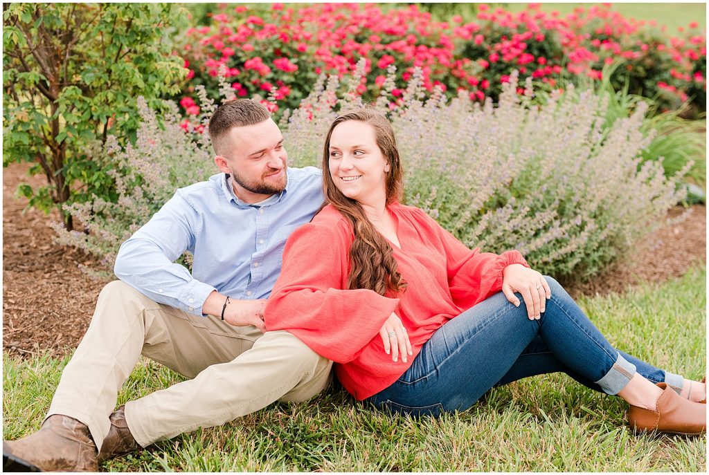 engagement session couple wearing red and blue in front of lavender and flowers