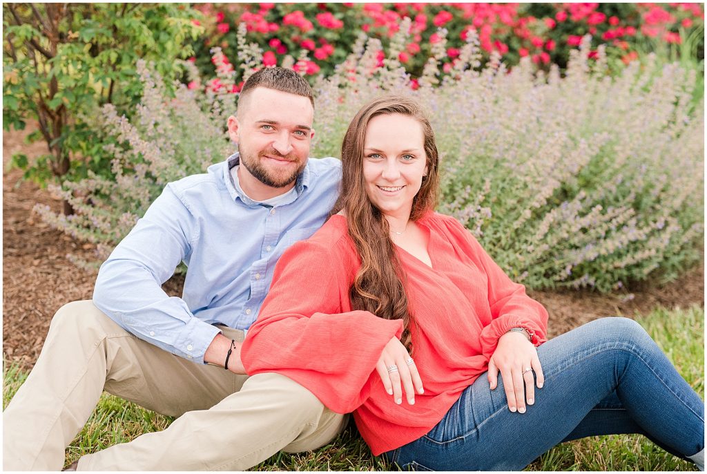 engagement session couple wearing red and blue sitting in front of lavender and flowers