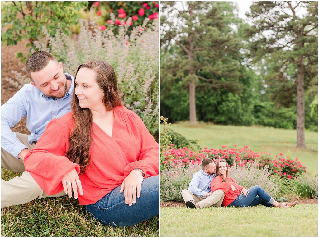 engagement session couple smiling at each other wearing red and blue sitting in front of lavender and flowers