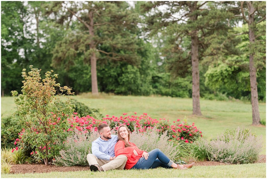 engagement session couple wearing red and blue sitting in front of lavender and flowers