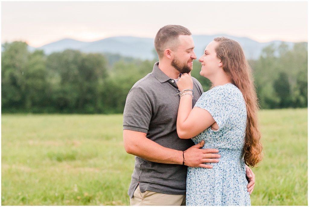 engagement session couple hugging in field at edgewood barn venue with shenandoah mountain view