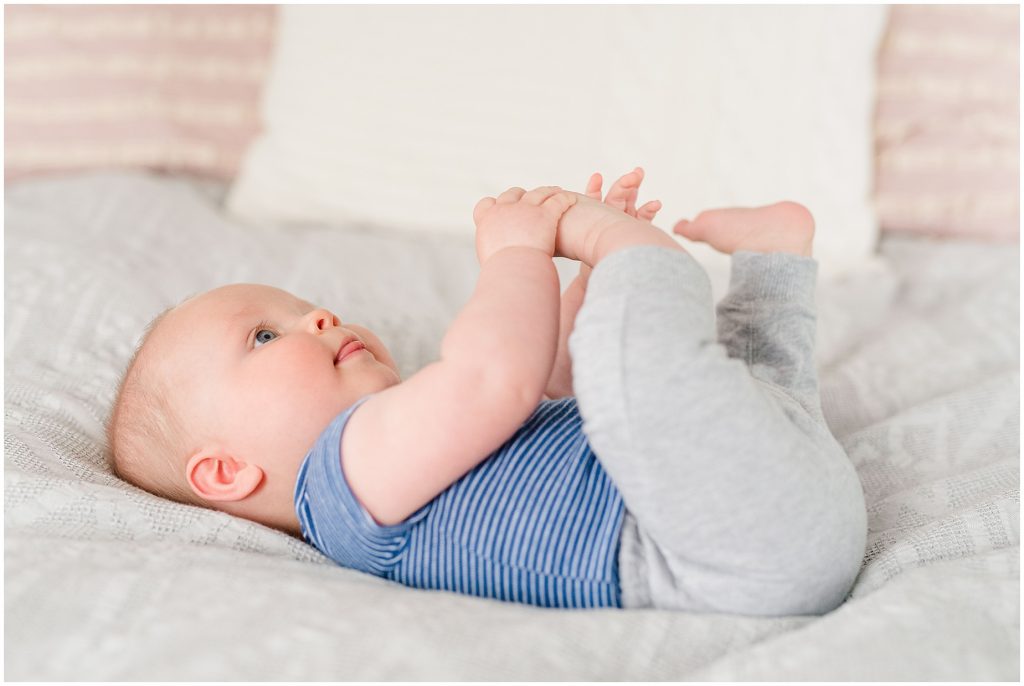 Richmond photographers niles lying on bed in blue onesie and pants