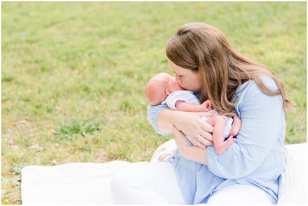 mom kissing newborn baby