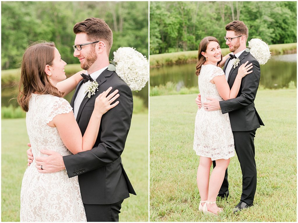 Bride and groom wrapped up together in front of lake at barn at edgewood