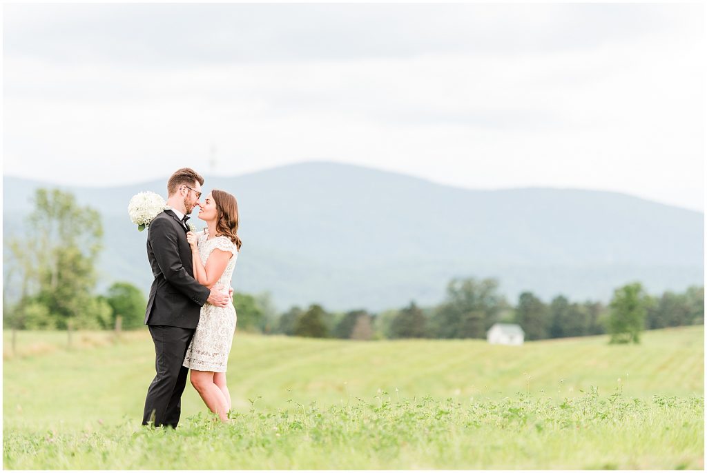 Bride and groom kissing in open field at the barn at edgewood after coronavirus mini wedding