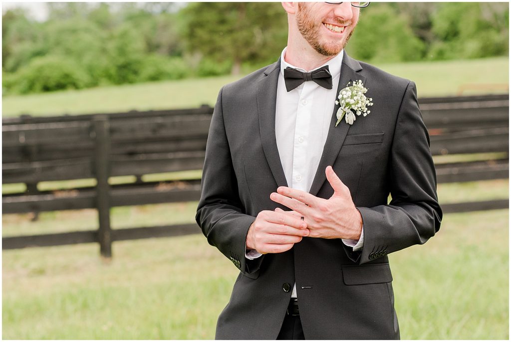 groom playing with ring after just getting married at barn at edgewood