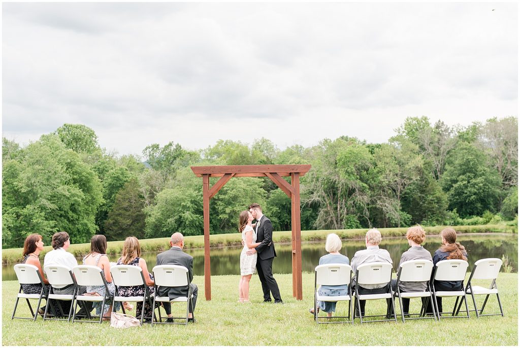 barn at edgewood coronavirus mini wedding bride and groom sharing first kiss at altar