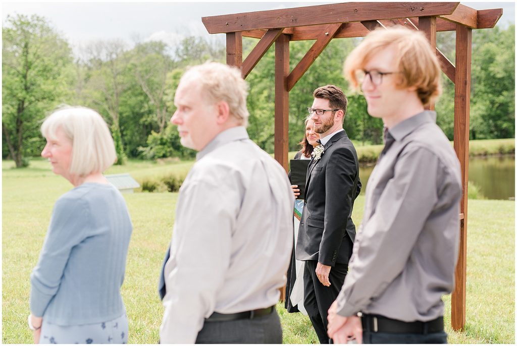 white barn at edgewood summer mini wedding groom watching bride walk down aisle