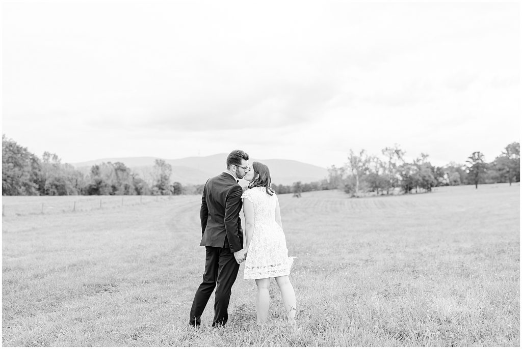 wedding couple kissing in open field at the barn at edgewood after coronavirus mini wedding