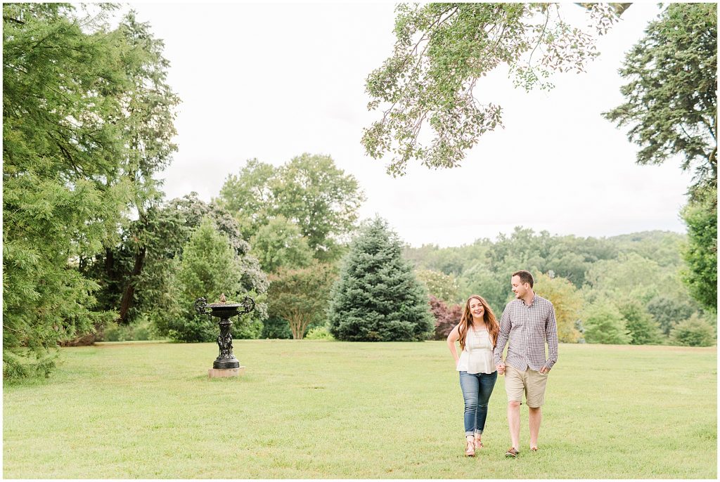 maymont park engagement session couple walking in field after raining