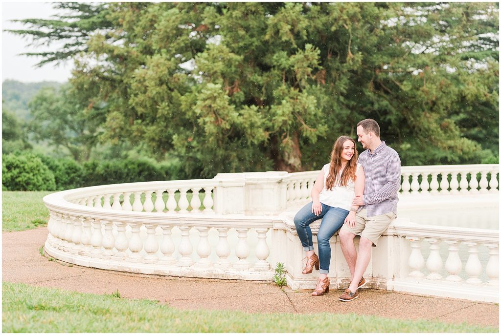 engagement session couple at maymont park sitting at pearl fountain while it rains