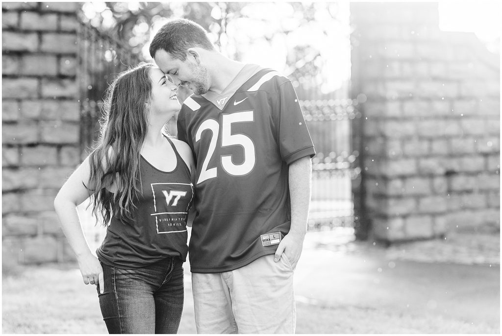 rainy engagement session couple at maymont park gate in virginia tech shirts
