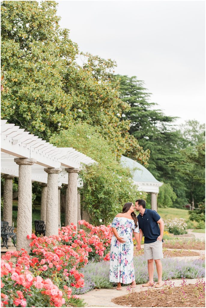 maymont maternity couple with white dress and navy polo kissing in Richmond Virginia