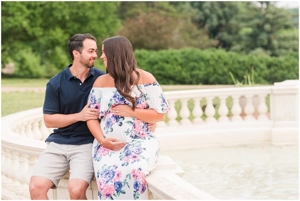 maymont park maternity couple sitting next to fountain in Richmond Virginia