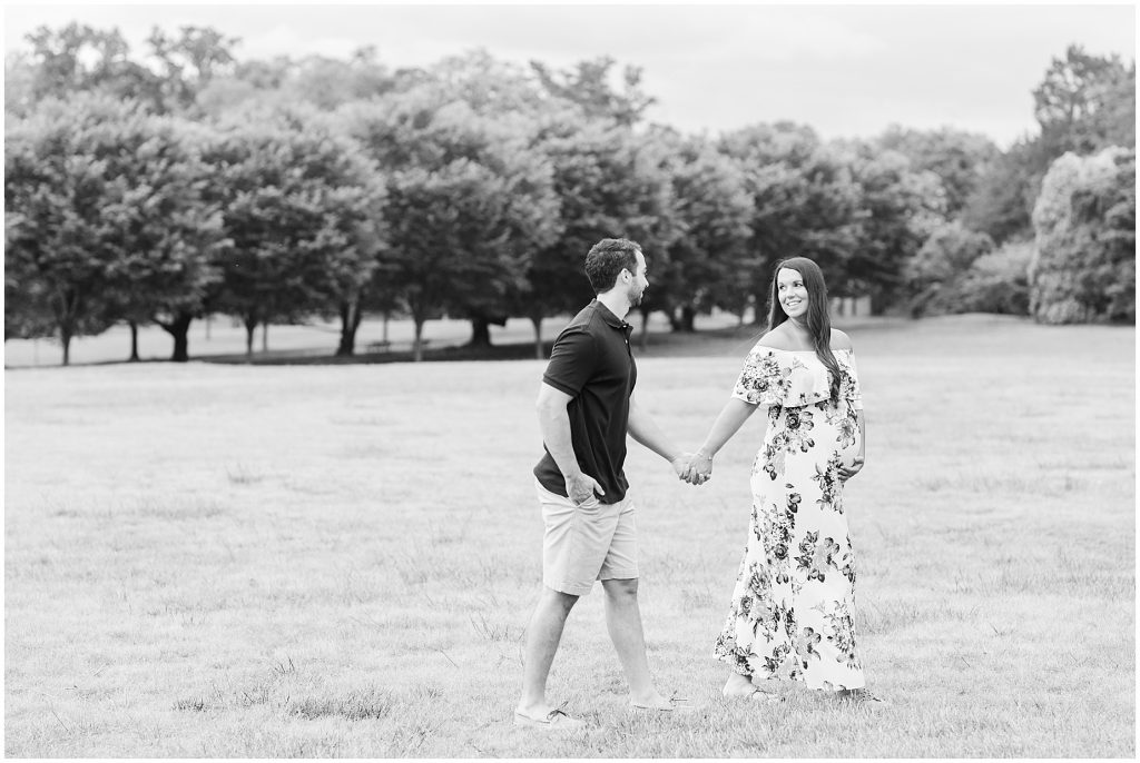 maymont park maternity couple walking in open field in black and white