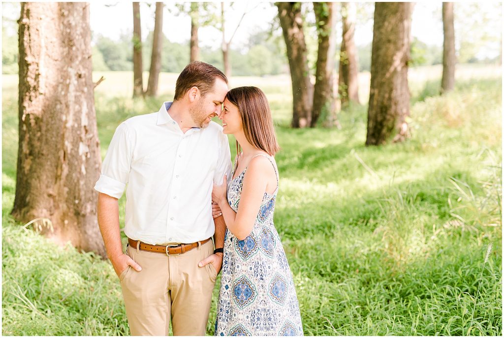 sunny Lansdowne resort engagement session couple in grassy field at a golf course in Leesburg