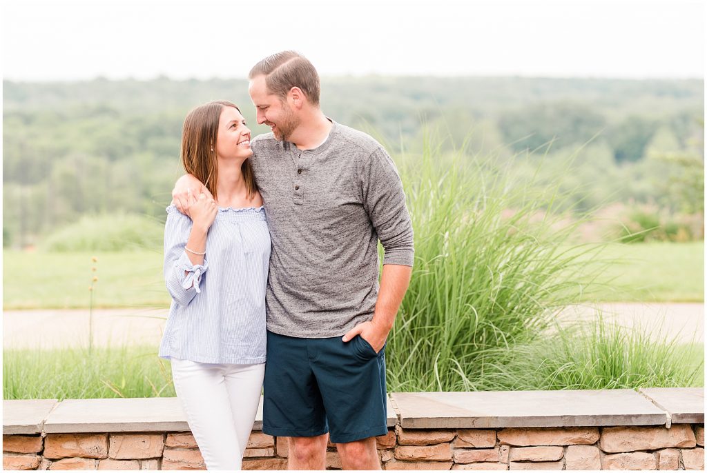 Lansdowne golf resort engagement couple standing at a stone wall at a golf course