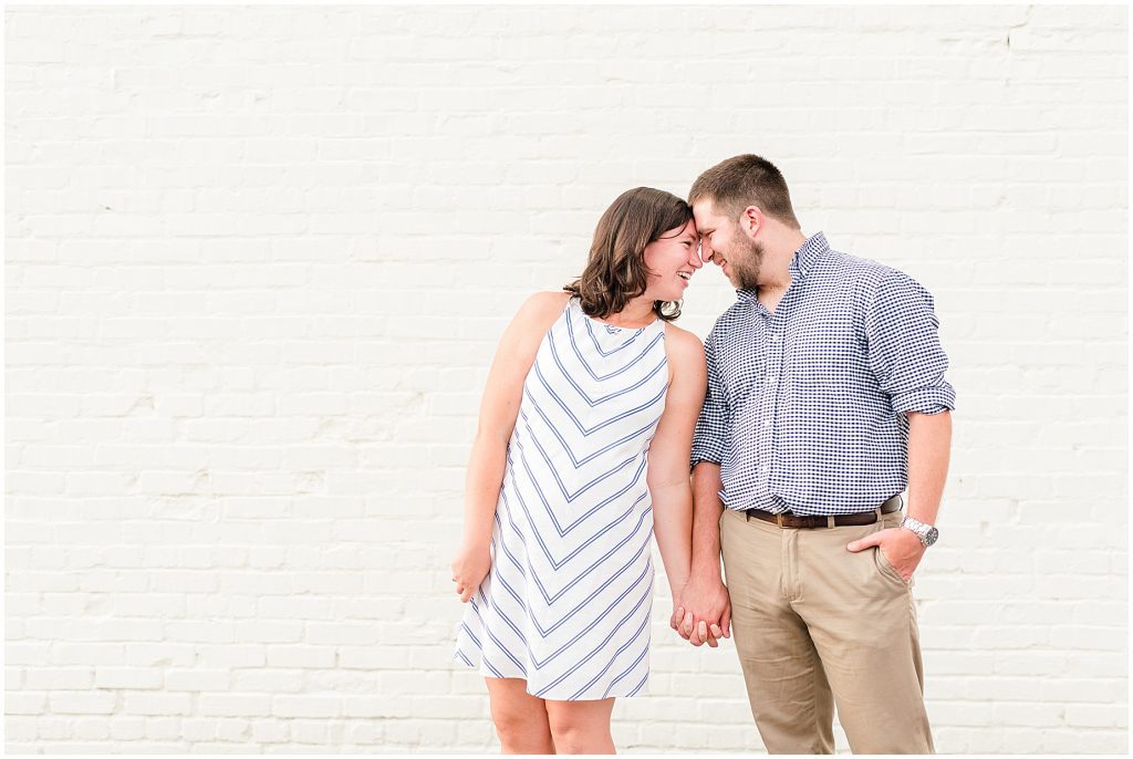 richmond engagement couple at Libbie & Grove area standing in front of white brick wall 