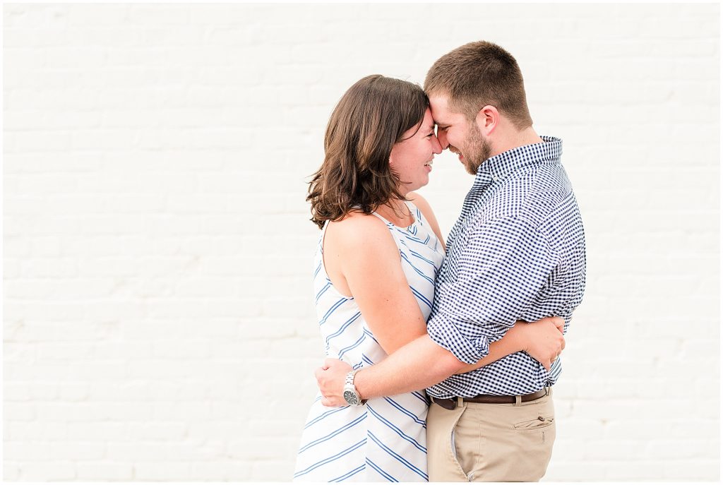 richmond engagement couple at Libbie & Grove area standing in front of white brick wall 