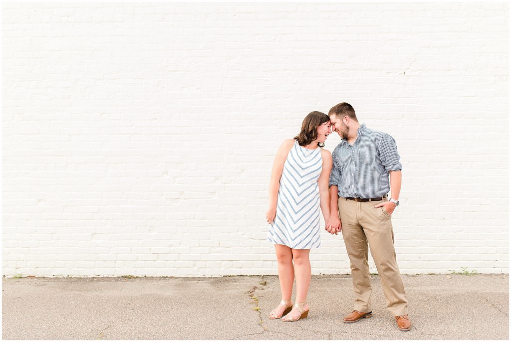 richmond engagement couple at Libbie & Grove area standing in front of white brick wall 