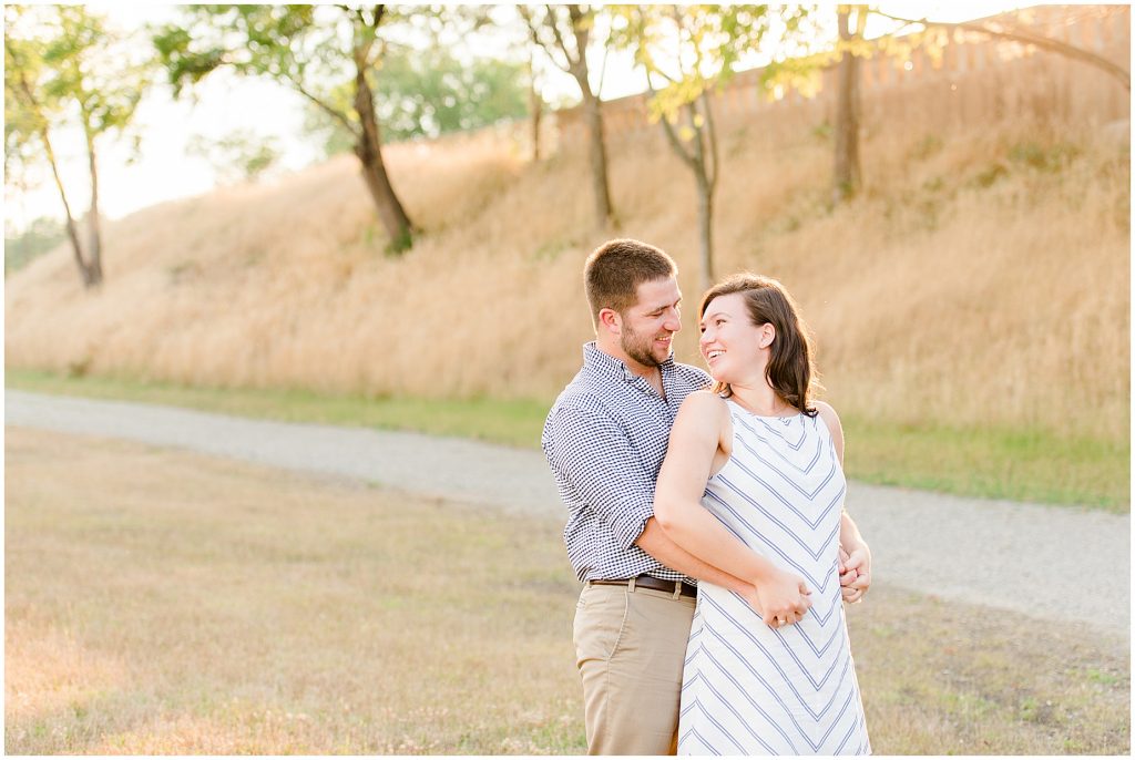 richmond engagement couple at the tredegar ironworks hill near browns island with glowy sun behind