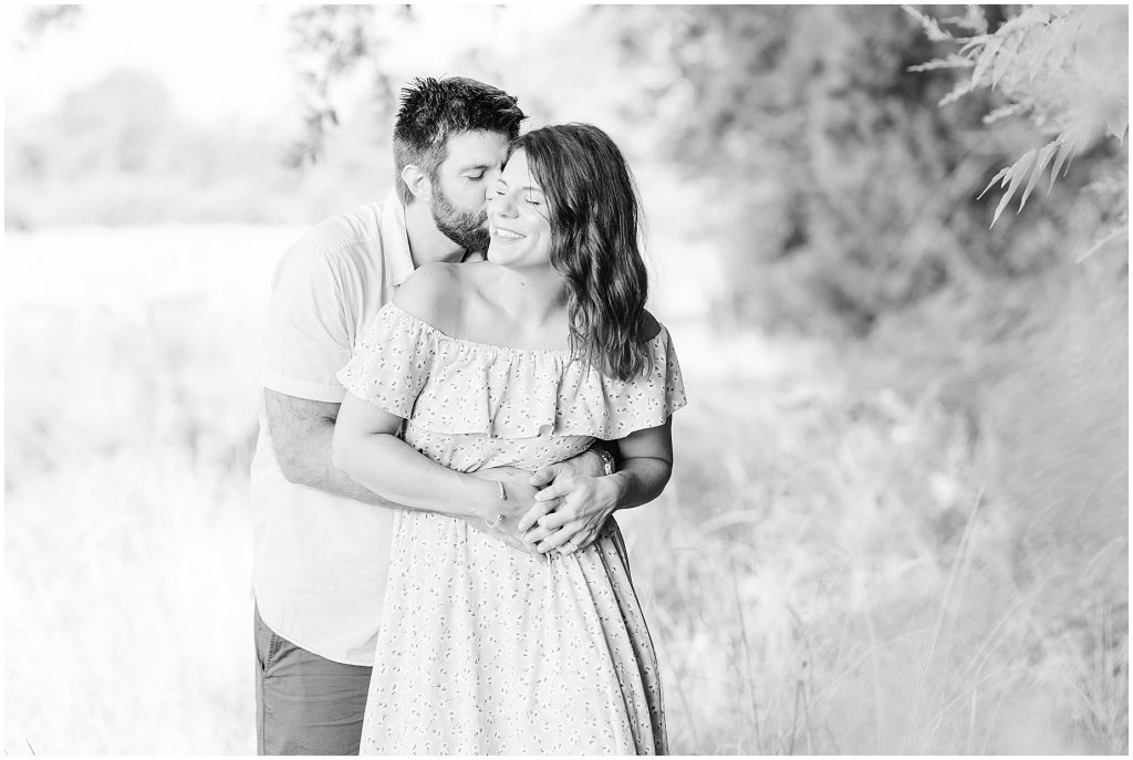west end richmond engagement session couple sitting in tall grass field