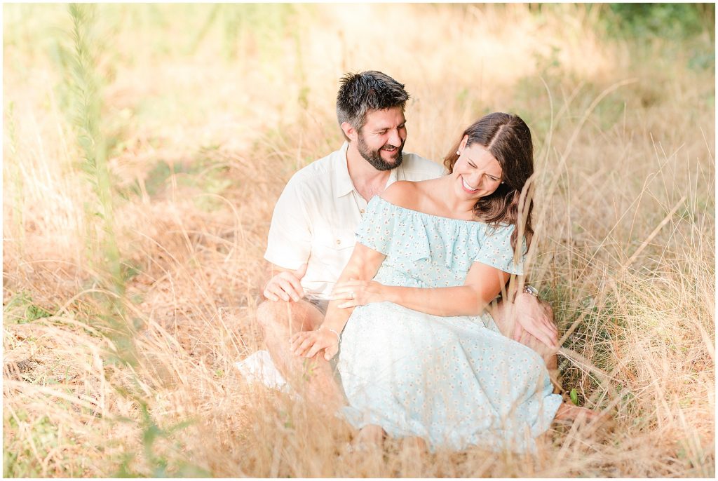 west end richmond engagement session couple sitting in tall grass field