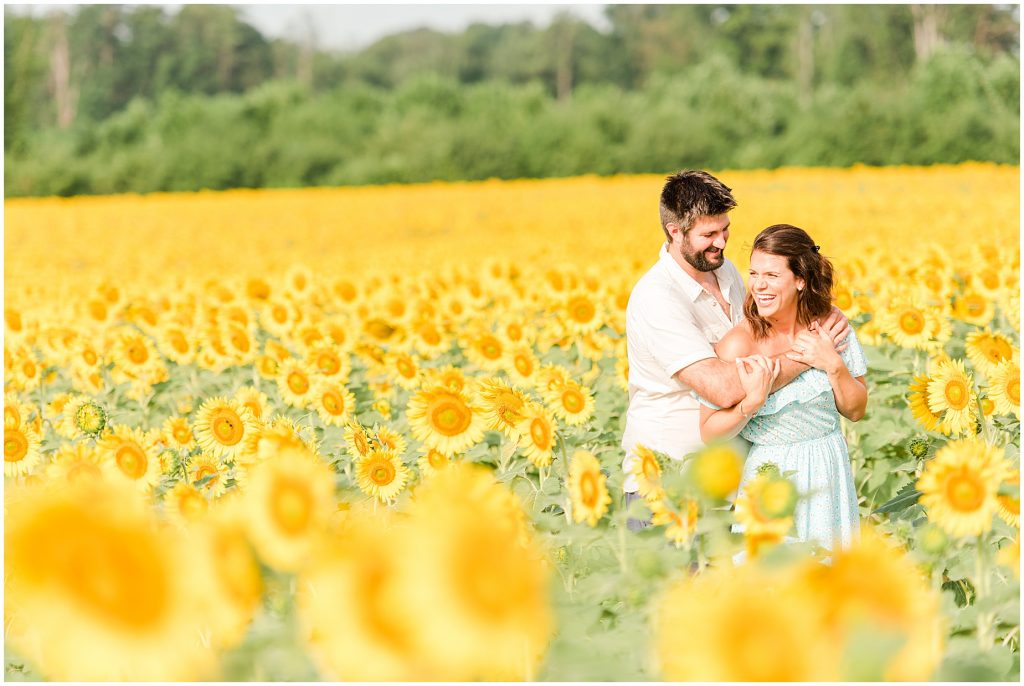 couple in sunflower fields engagement session Alvis Farms Richmond