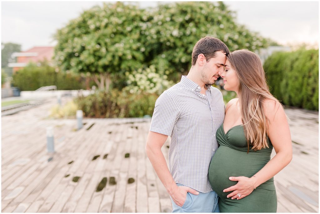 VMFA richmond maternity session with couple wrapped up on each other on pavillion