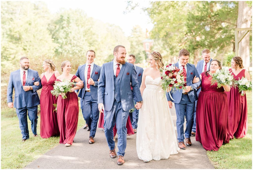 bridal party at wisteria farms blue suits and red dresses