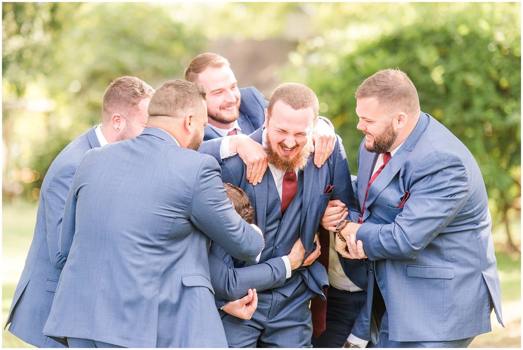 bridal party at wisteria farms blue suits and red dresses