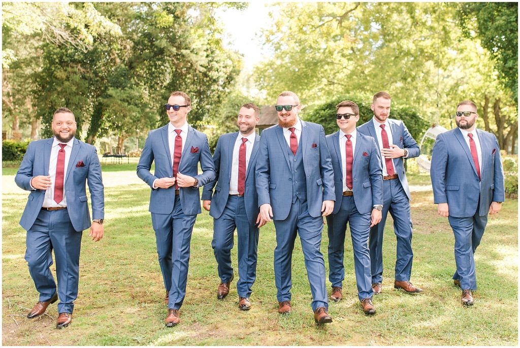bridal party at wisteria farms blue suits and red dresses