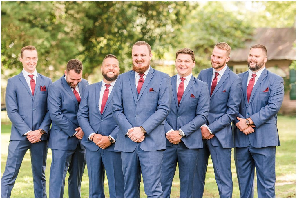 bridal party at wisteria farms blue suits and red dresses