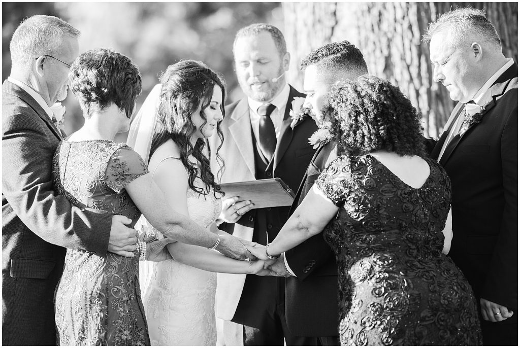 parents praying with bride and groom at ceremony at amber grove virginia wedding venue 