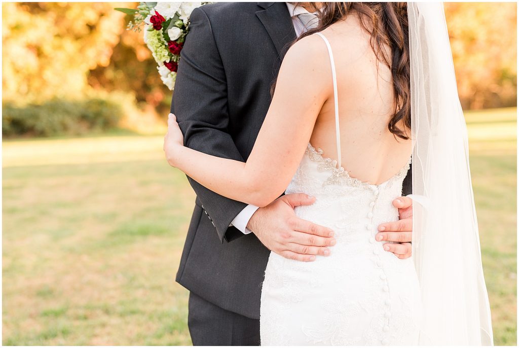 bride and groom attire detail in field with fall color trees at Amber grove in richmond