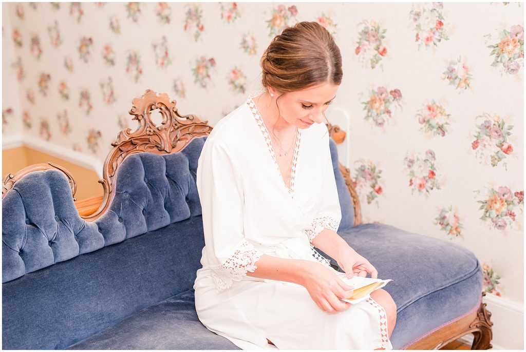 bride reading note from groom in white robe at waverly estate in southern virginia