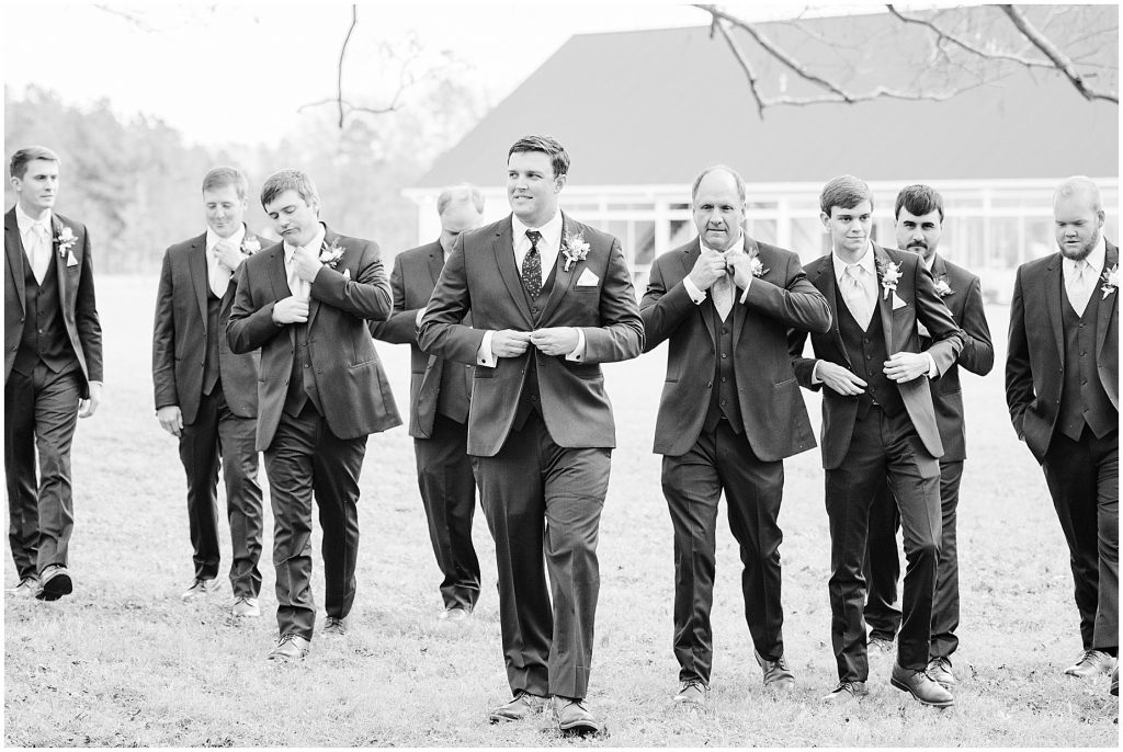 groom and groomsmen walking to ceremony at waverly estate in southern virginia in black and white