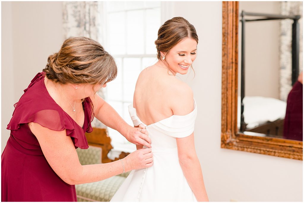 brides mother helping bride button her wedding dress in plantation getting ready room at Waverly Estate in southern Virginia