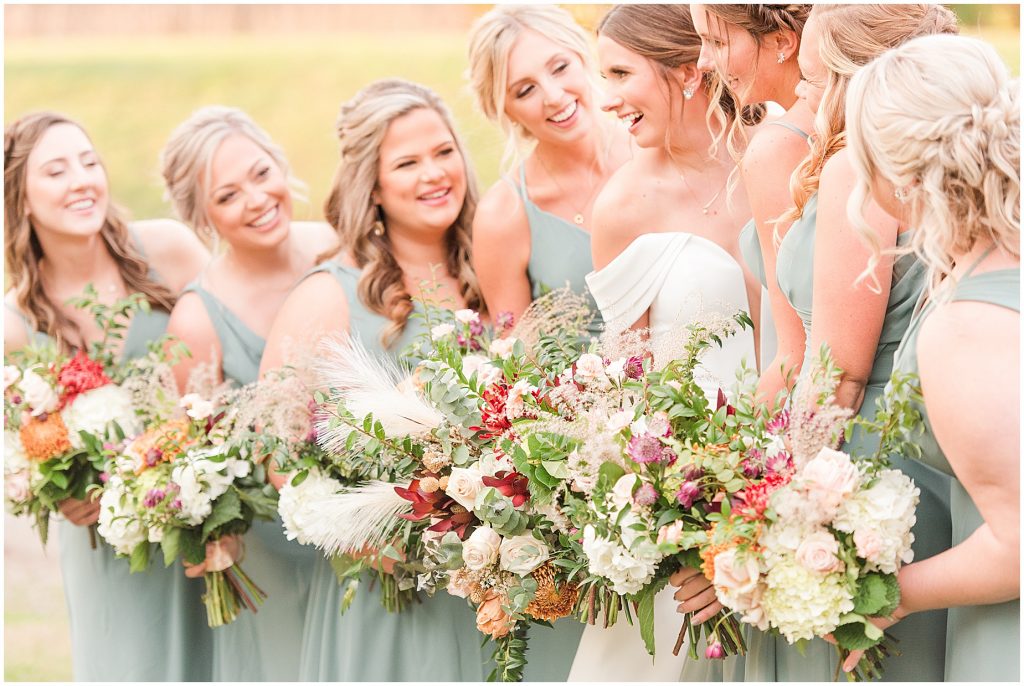 bride and bridesmaids laughing with beautiful flowers in mint dresses at Waverly Estate
