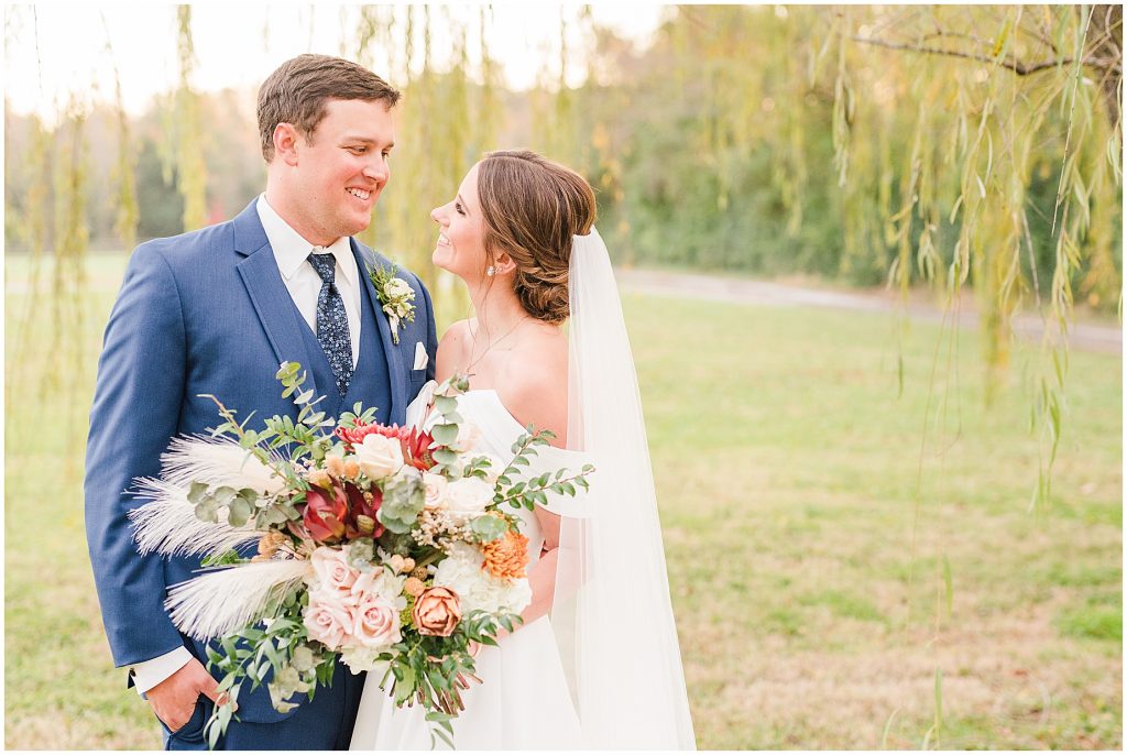 bride and groom standing in a willow tree at Waverly Estate in southern Virginia