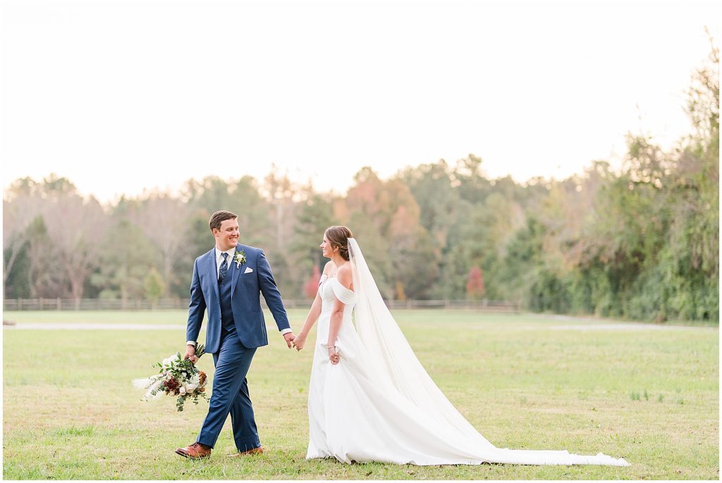 bride and groom walking in field at Waverly Estate in southern Virginia