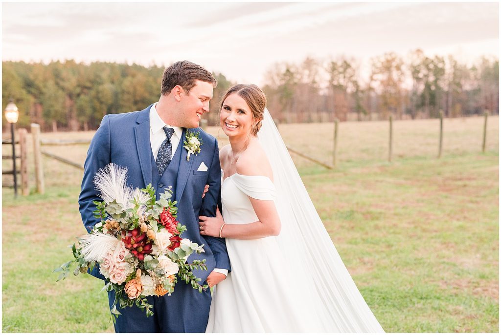 bride and groom walking in field at Waverly Estate in southern Virginia