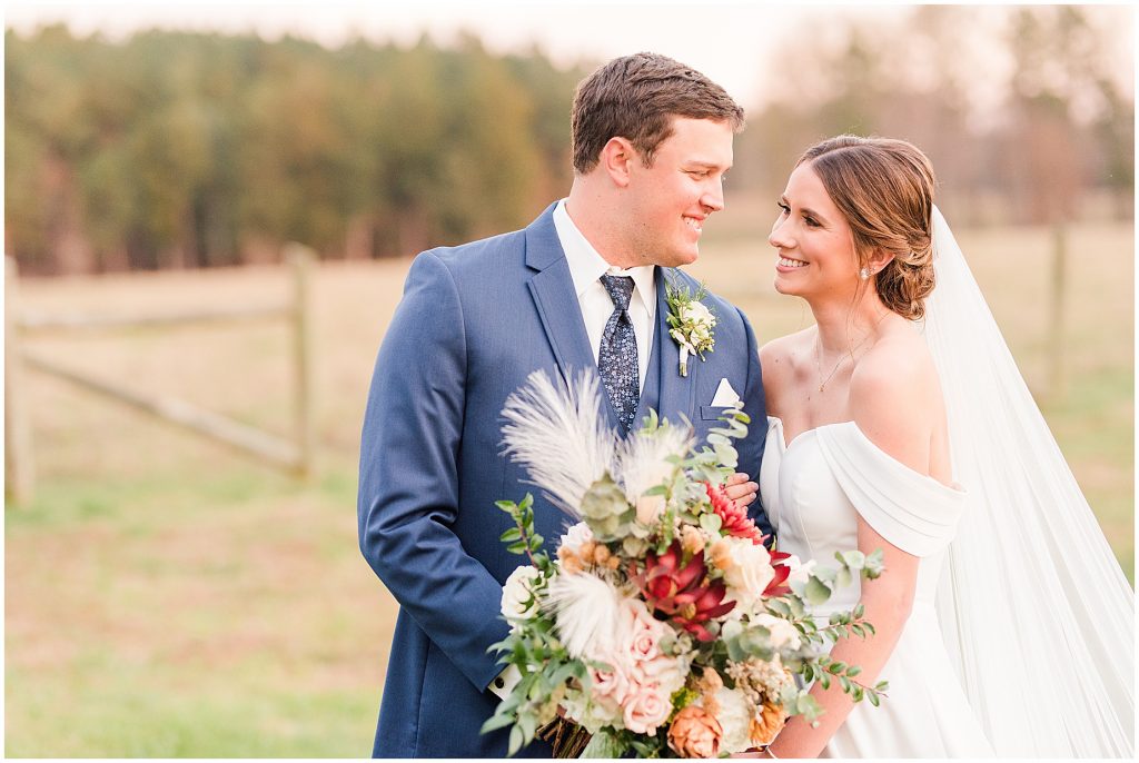 bride and groom laughing in field at Waverly Estate in southern Virginia