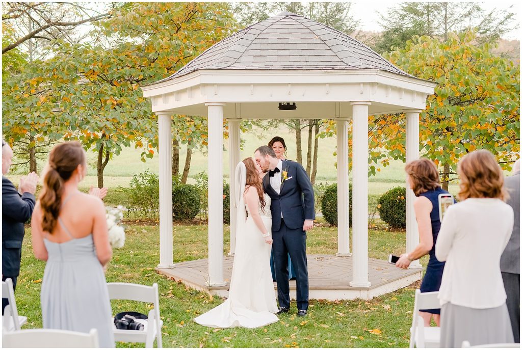 kiss at mini wedding ceremony outside at whitehall estate in bluemont virginia