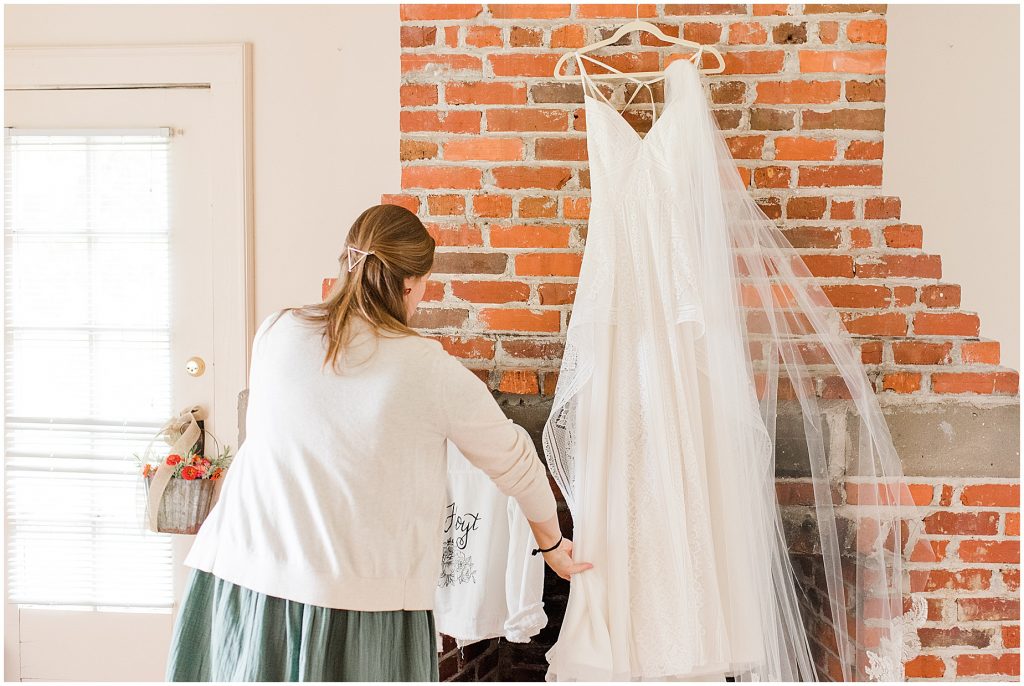 photographer taking details of wedding dress in getting ready space