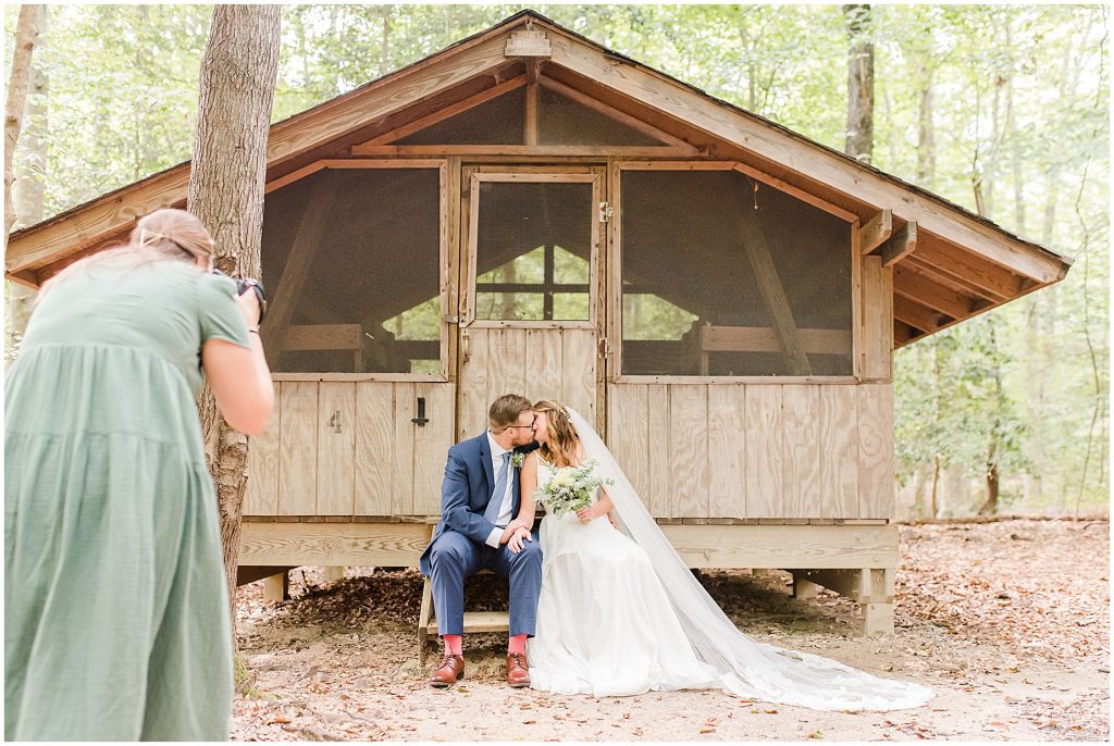 Virginia Photographers Behind the Scenes taking portraits of bride and groom at cabin at Chanco