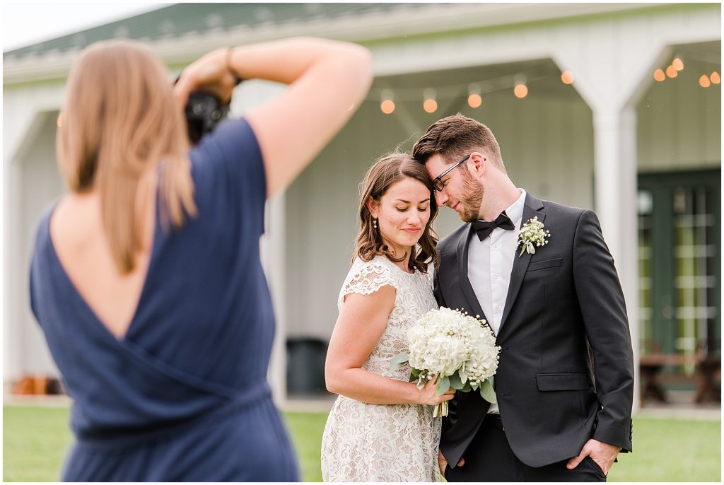 bride and groom with photographer in a field at edgewood barn in Charlottesville