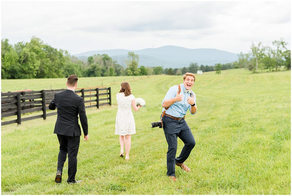 bride and groom with Virginia Photographers Behind the Scenes walking in a field at edgewood barn in Charlottesville