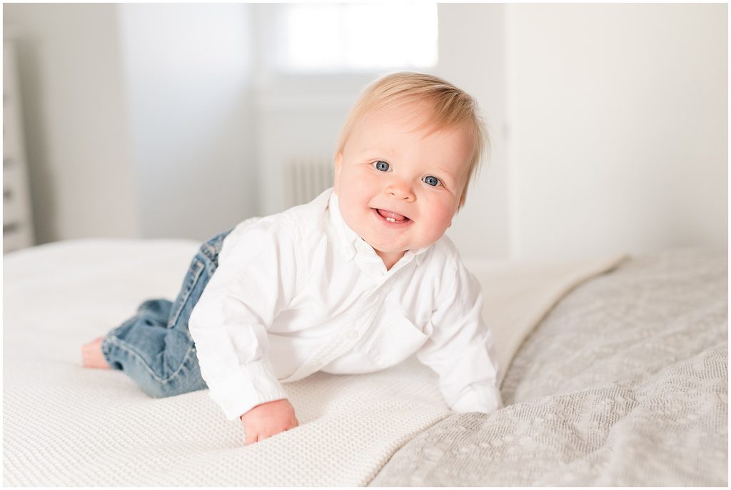 baby boy crawling on bed in handsome outfit